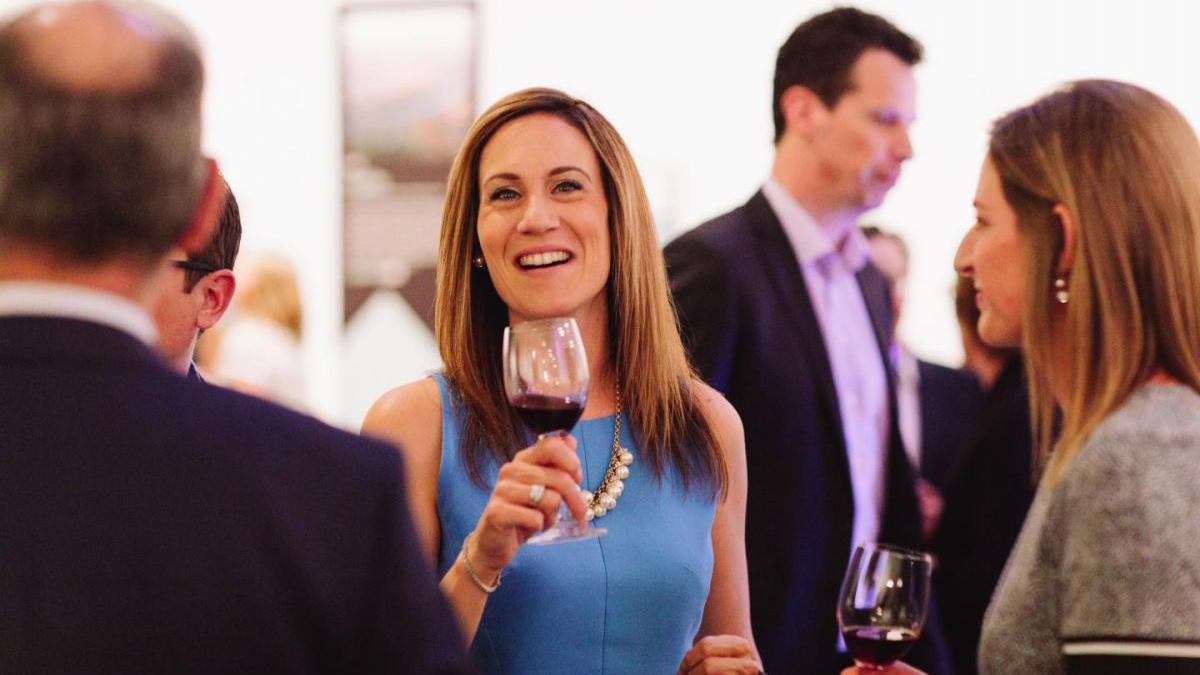 Woman holding a glass of wine at charity event