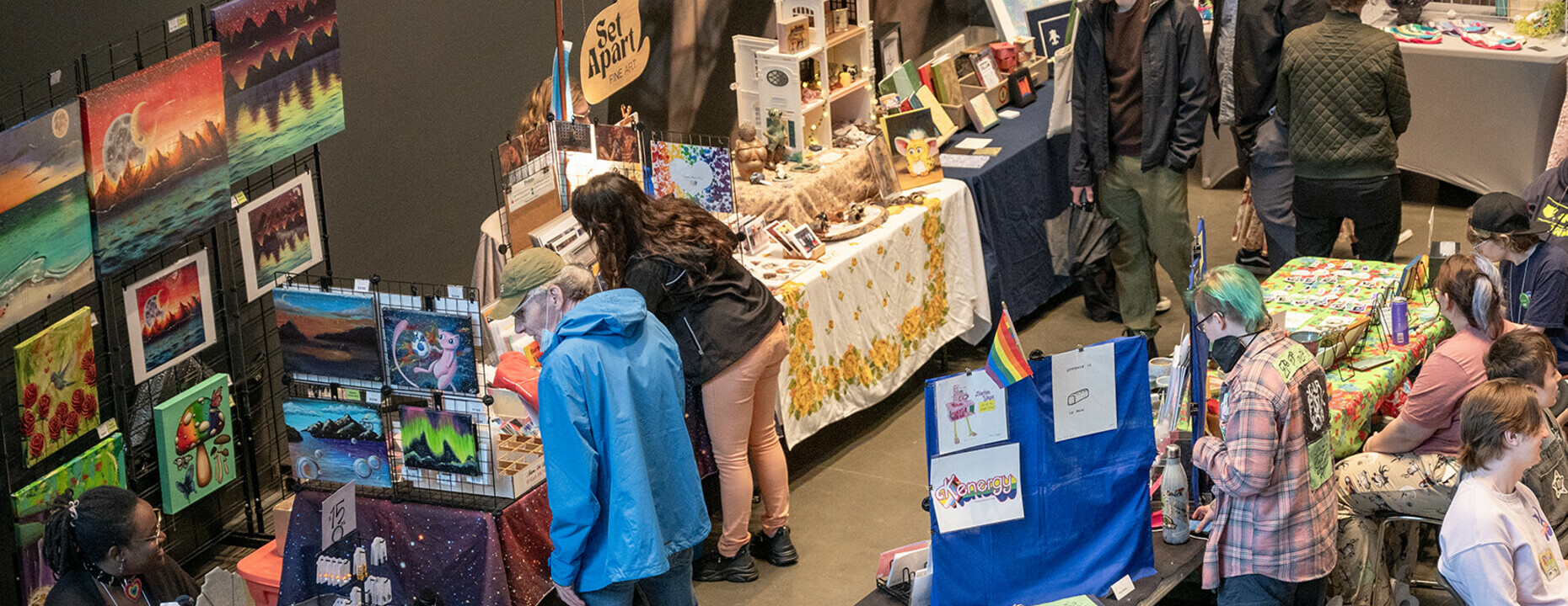 A group of people explore vendor stands in the AGA Main Hall.