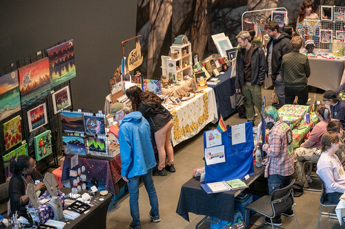 A group of people explore vendor stands in the AGA Main Hall.